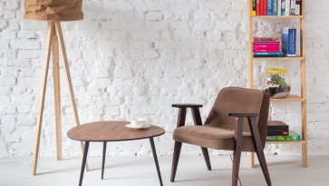 Kącik kawowy z wygodnym fotelem i drewnianym stolikiem na trzech nogach
