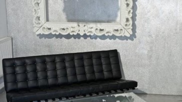 Pikowana sofa 3-osobowa z czarnej skóry naturalnej w salonie ze strukturą dekoracyjną na ścianie