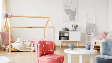 Pokój dziecięcy z kolorowymi fotelikami i okrągłym stolikiem w kolorze białym