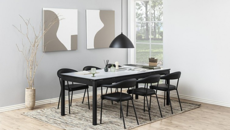 Czarne meble jadalniane duży stół i sześć z krzeseł z ekoskóry w przestronnej jadalni