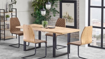 Jadalnia w stylu industrialnym z stołem na płozach w towarzystwie częściowo tapicerowanych krzeseł