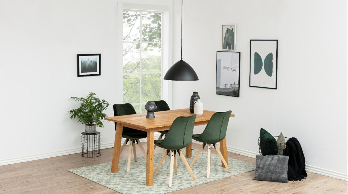 Drewniany stół czteroosobowy z krzesłami w stylu skandynawskim na zielonym dywanie