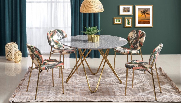 Okrągły stół z blatem imitującym marmur w zestawieniu z tapicerowanymi krzesłami w stylu glamour