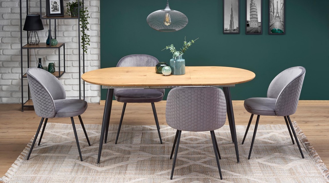 Owalny stół z tapicerowanymi krzesłami na czterech nogach w loftowej jadalni