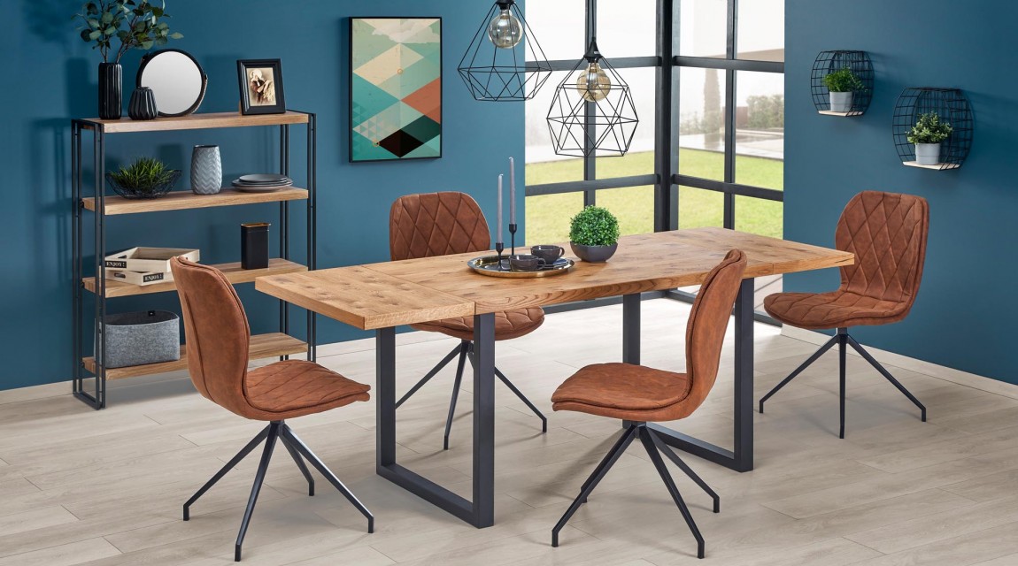 Industrialny stół z fornirowanym blatem w towarzystwie pikowanych krzeseł