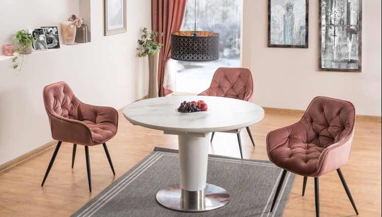 Biały stół okrągły z funkcją rozkładania i kubełkowe krzesła pikowane w eleganckiej jadalni
