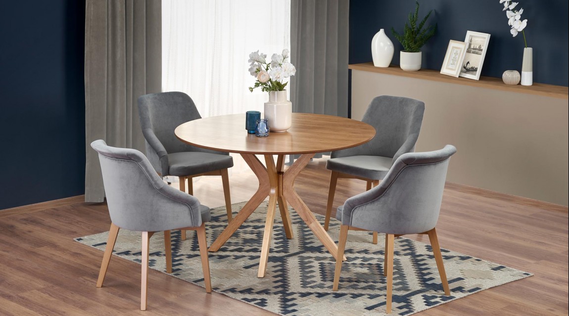 Okrągły stół w towarzystwie tapicerowanych krzeseł w eleganckiej jadalni