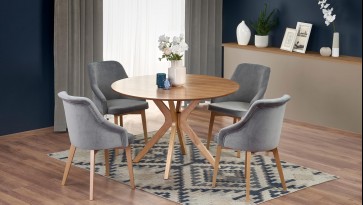 Okrągły stół w towarzystwie tapicerowanych krzeseł w eleganckiej jadalni