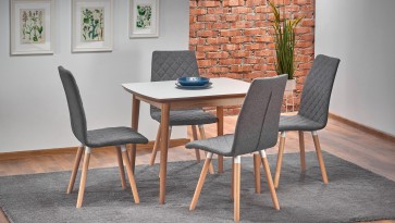 Rozkładany stół w stylu skandynawski w towarzystwie tapicerowanych krzeseł