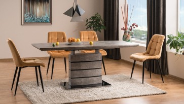 Stół z funkcją rozkładania imitujący strukturę betonu i pikowane krzesła aksamitne w salonie połączonym z jadalnią