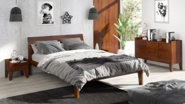 Klimatyczna sypialnia z drewnianymi meblami na nóżkach