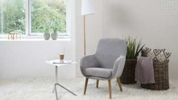 Kącik wypoczynkowy w stylu skandynawskim z szarym fotelem
