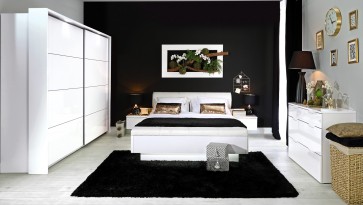 Białe meble do sypialni na tle czarnej ściany