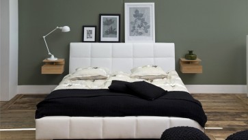Nowoczesna sypialnia z białym łóżkiem z pikowanej ekoskóry i ciemnozielonymi ścianami