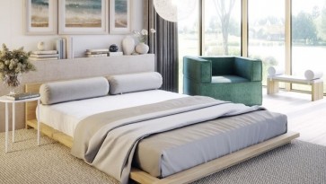Niskie łóżko na szarym dywanie w sypialni z dużym oknem i jasnymi ścianami
