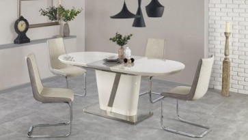 Stół z lakierowanym i rozkładanym blatem oraz krzesła na metalowych płozach w jadalni z szarą podłogą i elementami dekoracyjnymi