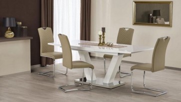 Lakierowany stół z rozkładanym blatem i tapicerowane krzesła w klimatycznej jadalni z brązowymi zasłonami i lustrem w złotej ramie