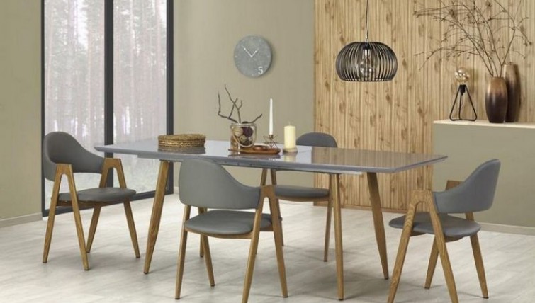 Rozkładany stół z lakierowanym blatem i krzesła tapicerowane ekoskórą  w jadalni z popielatymi ścianami