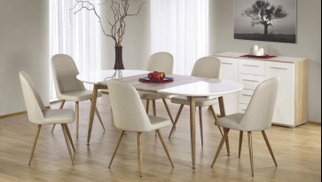 Rozkładany stół z owalnym blatem i krzesła z ekoskóry w jadalni z komodą oraz obrazem na tle popielatej ściany