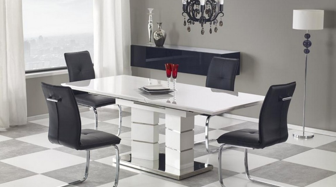 Biały stół rozkładany z lakierowanym blatem na ozdobnej nodze w zestawie z krzesłami na płozach ze skóry ekologicznej