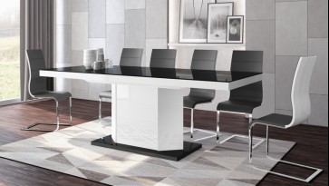 Czarno-biały stół z rozkładanym blatem w towarzystwie krzeseł z ekoskóry w nowoczesnej jadalni z drewnianą podłogą