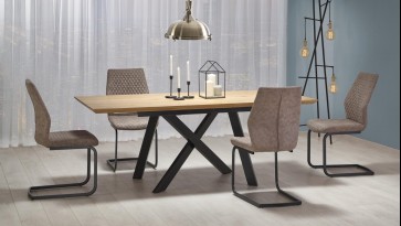 Rozkładany stół na metalowych nogach w zestawie z tapicerowanymi krzesłami w jadalnianej aranżacji