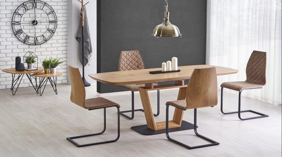 Rozkładany stół w nowoczesnej jadalni z krzesłami na metalowych płozach w towarzystwie białych i szarych ścian