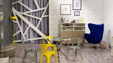 Nowoczesna aranżacja salonu z metalowymi krzesłami w stylu loftowym i tapicerowanym fotelem wypoczynkowym