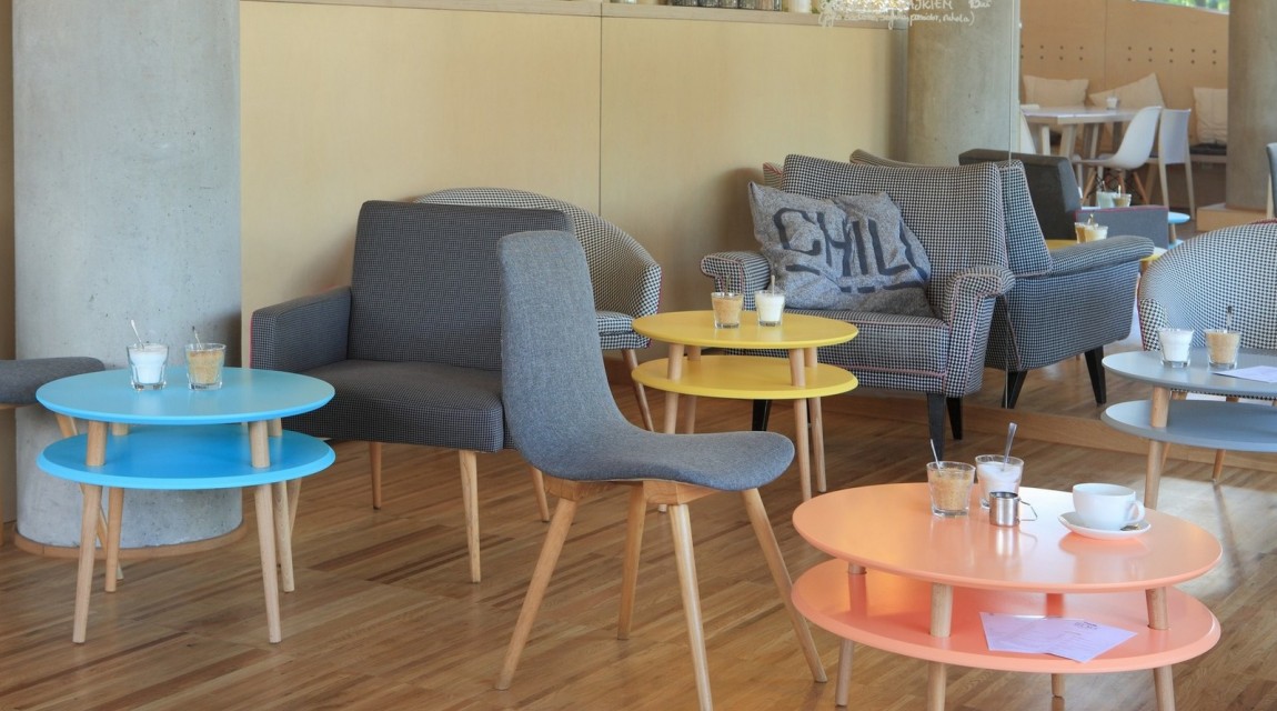Kolorowe stoliki kawowe w stylu skandynawskim w nowoczesnym wnętrzu kawiarnianym
