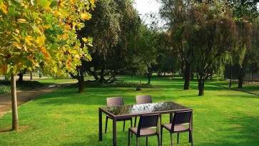 Stół do ogrodu ze szklanym blatem oraz brązowe profilowane krzesła bez podłokietników