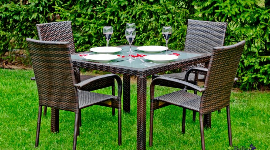 Zestaw mebli dla czterech osób ze stołem i szklaną nakładką w przydomowym ogrodzie