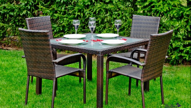 Zestaw mebli dla czterech osób ze stołem i szklaną nakładką w przydomowym ogrodzie