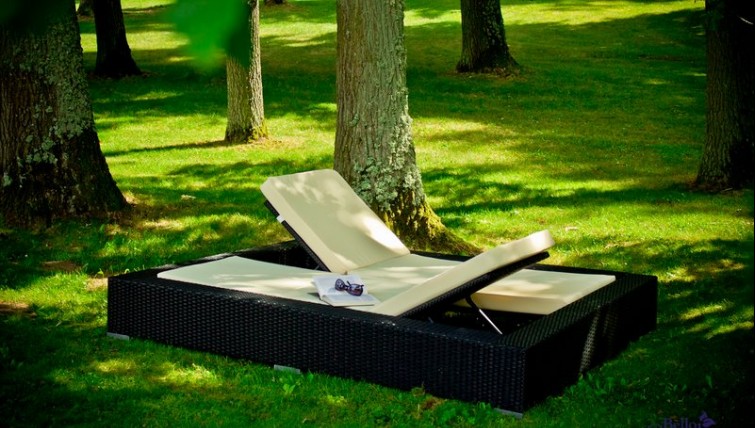 Ekskluzywne łóżko dwuosobowe z regulacjami w zalesionym ogrodzie ustawione w cieniu drzew
