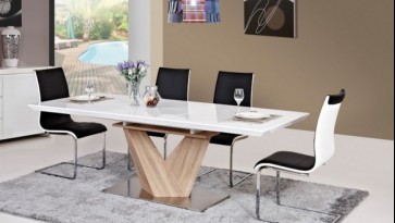 Biało-czarne krzesła na metalowych płozach i biały rozkładany stół z blatem o połyskującej powierzchni