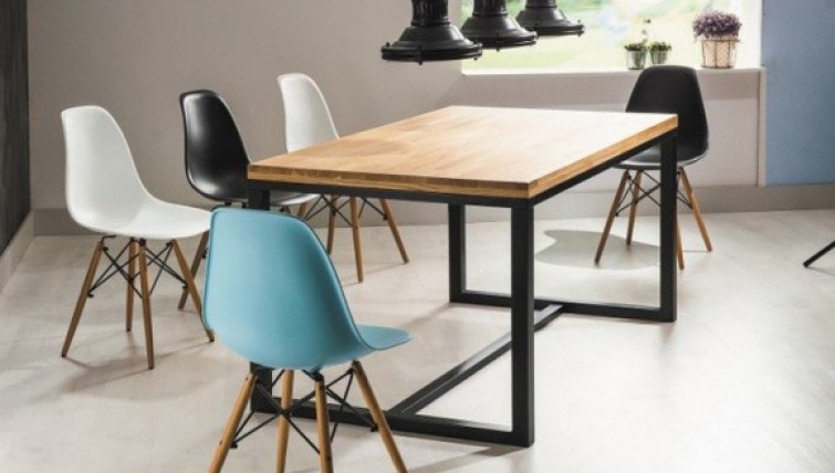 Stół z drewnianym blatem na metalowej podstawie i kolorowe krzesła bez podłokietników