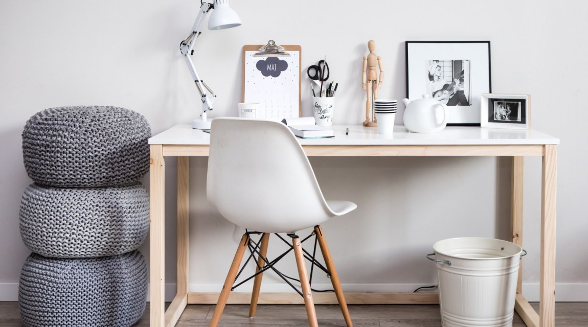 Biurko z prostokątnym blatem na drewnianej podstawie oraz białe krzesło w stylu skandynawskim
