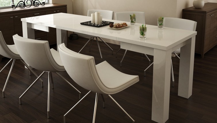 Rozkładany biały stół w wysokim połysku i skórzane krzesła na metalowych nóżkach w jadalni z ciemną podłogą