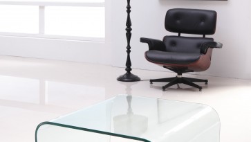 Designerski fotel skórzany w towarzystwie kwadratowego stolika z bezbarwnego szkła giętego
