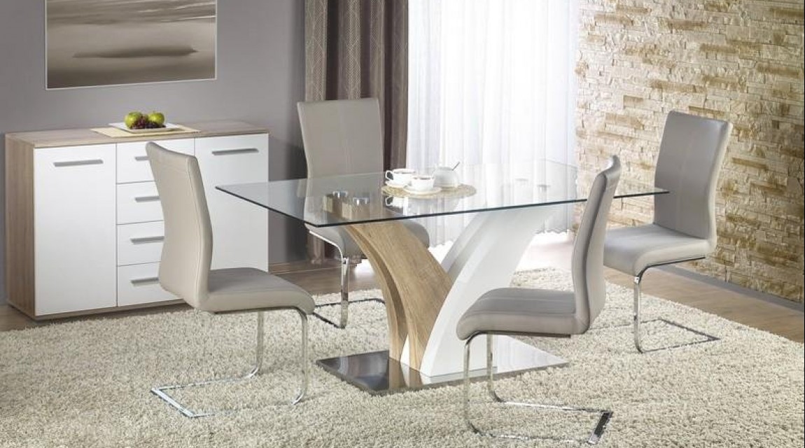 Szklany stół na ozdobnej nodze i krzesła na chromowanych płozach w nowoczesnym wnętrzu domowym