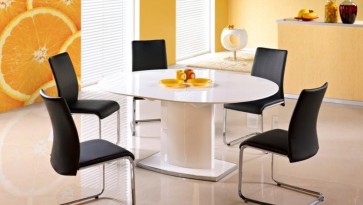 Biały stół lakierowany z owalnym blatem rozkładanym i czarne krzesła na metalowych płozach
