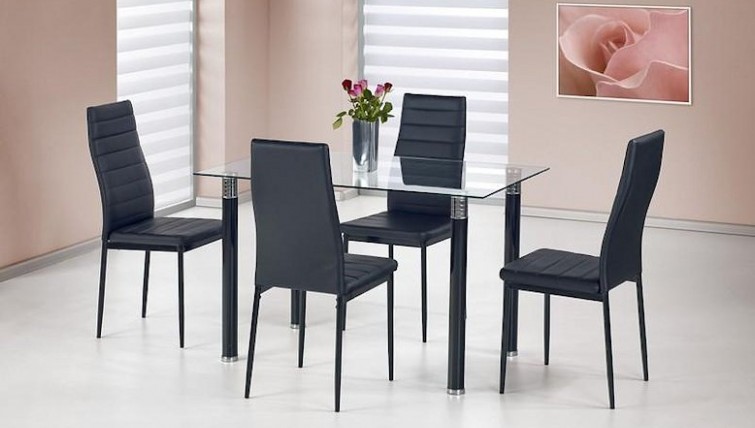 Krzesła tapicerowane ekoskórą w towarzystwie stołu ze szklanym blatem w jadalni z różowymi ścianami i dużym obrazem
