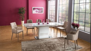 Rozkładany stół z blatem w dekorze marmur i krzesła tapicerowane beżową tkaniną