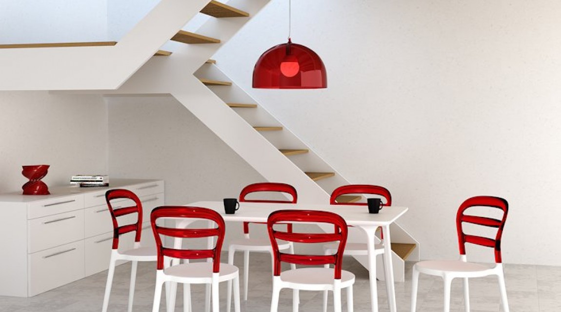 Kolorowe krzesła z tworzywa bez podłokietników i prostokątny biały stół w awangardowej jadalni