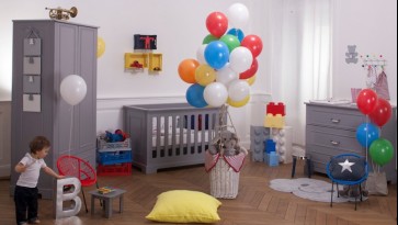 Zestaw mebli w kolorze szarym z łóżeczkiem i dwudrzwiową szafą na ubranka w pokoju dla dziecka