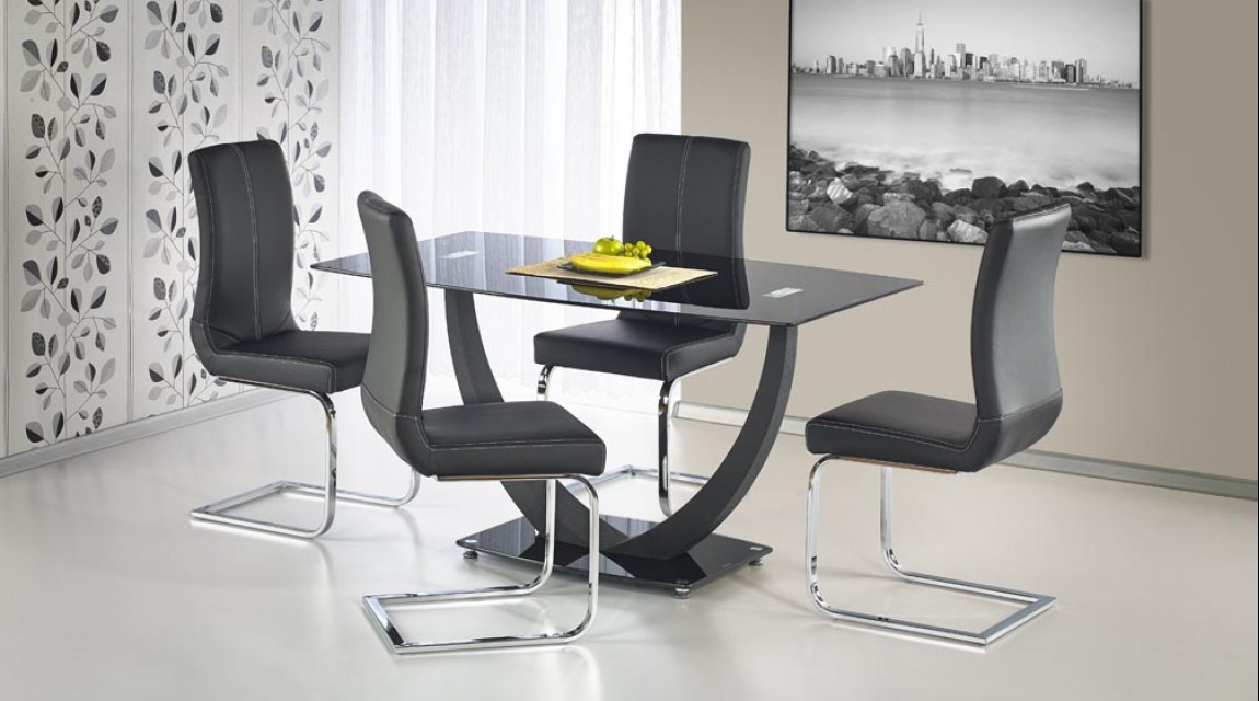 Nierozkładany stół ze szklanym blatem oraz tapicerowane ekoskórą krzesła na metalowych płozach