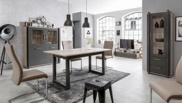 Rozkładany stół na płozach oraz przeszklone witryny w stylu industrialnym
