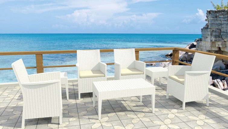 Wypoczynkowe fotele ogrodowe z wysokimi podłokietnikami oraz stoliki kawowe i prostokątna ława
