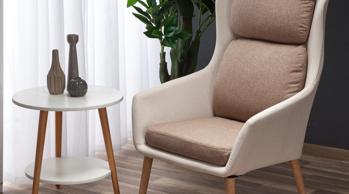 Fotel wypoczynkowy z miękkim siedziskiem ustawiony przy oknie w nowoczesnym salonie