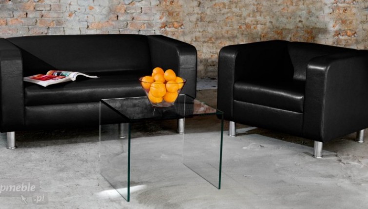 Czarna dwuosobowa sofa oraz fotel na metalowych nóżkach i szklany stolik kawowy
