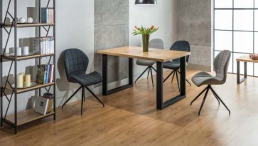 Nierozkładany stół z drewnianym blatem na metalowej podstawie i szare tapicerowane krzesła